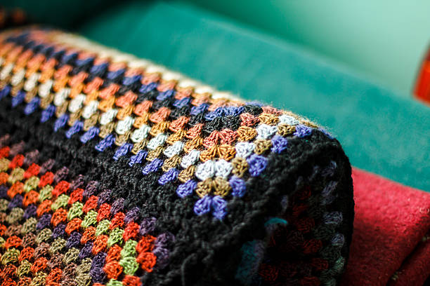 Rolled handmade crochet afghan blanket of granny squares. Rainbo stock photo