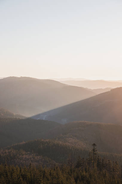 istock Sun rises from behind the mountain and the sun's rays gradually illuminate the valley in Beskydy mountains, Czech Republic 1859784109