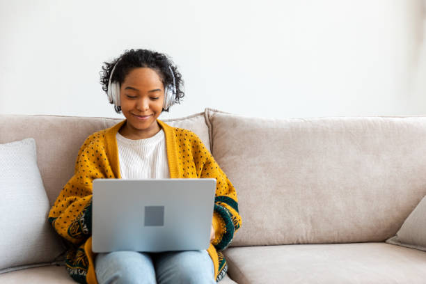 istock African american girl using laptop at home office looking at screen typing chatting reading writing email. Young woman having virtual meeting online chat video call conference Work learning from home 1859797785