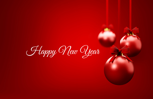 Red Christmas baubles and happy new year message over red background. Christmas and festivity concept. Horizontal composition with selective focus and copy space.