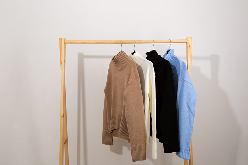 Warm sweaters with a stand-up collar hang on a trempel