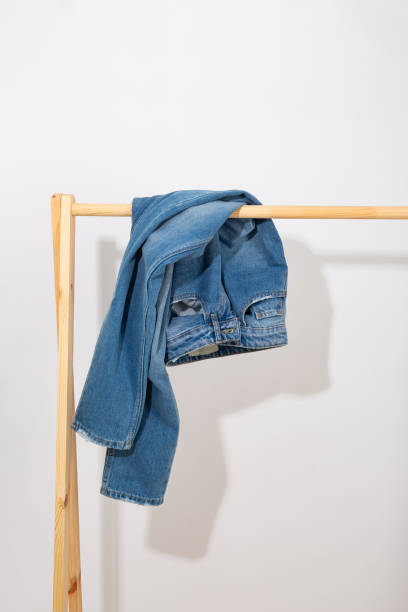istock Blue jeans denim pants on a wooden rack 1859798477