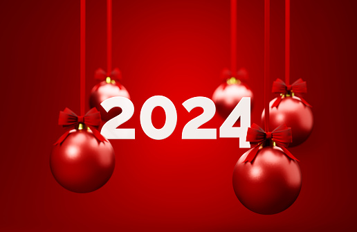Red Christmas baubles and 2024 over red background. Christmas and festivity concept. Horizontal composition with selective focus and copy space.