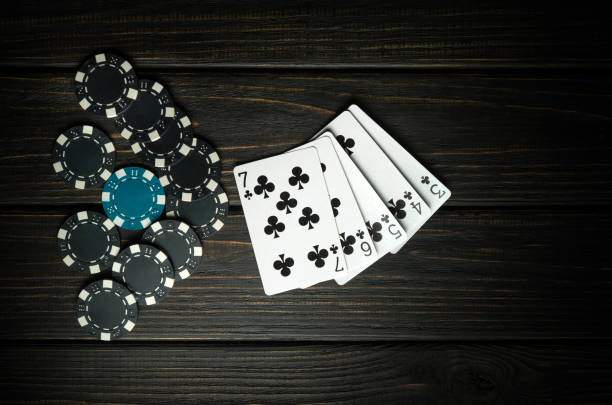 istock Popular poker game with straight flush winning combination. Cards with chips on a black vintage table in a poker club. Free black space for ads 1859802564