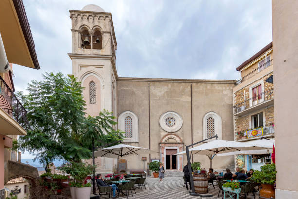 Castelmola, Sicily, Italy - November  09, 2023: Square in front of Cathedral of Castelmola, a church dedicated to St. Nicholas of Bari. It is a popular place with outdoor restaurants and gift shops