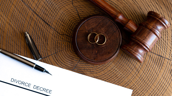 gavel and wedding rings on wooden table