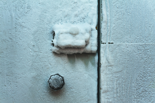 Frozen door with lock and handle indoors. Background.