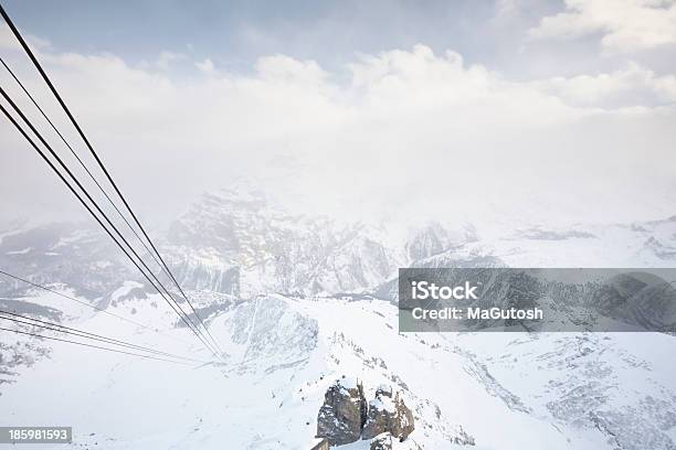 Photo libre de droit de Cable Cars Running Par Le Biais De Montagnes Enneigées banque d'images et plus d'images libres de droit de Alpes européennes