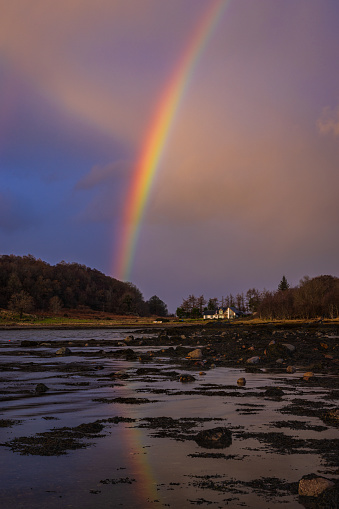 A rainbow reflects over the shore of Appin Bay