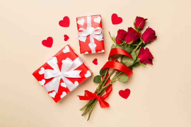 istock Valentines day gift box with red roses on color background, top view 1859823925