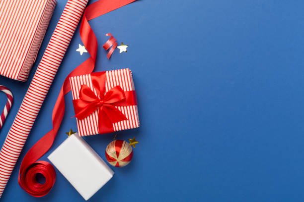 istock Gift boxes with paper's rools and christmas decoration on color background, top view 1859829642