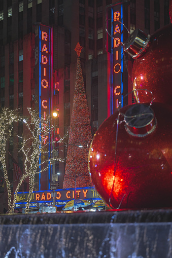 Radio City Music Hall with oversized Christmas ornaments in the foreground. December 2023. New York City, NY. USA