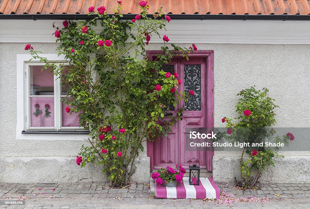 Roses decorating the house entrance Roses decorating the house entrance in the town of Visby (Gotland, Sweden). Visby Stock Photo