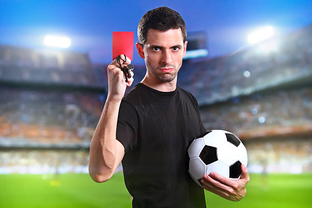 istock A referee holding a red card and football 185988409