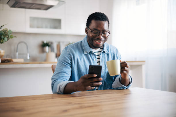 istock Shot of a young man with glasses using a smartphone and having coffee 1859907114