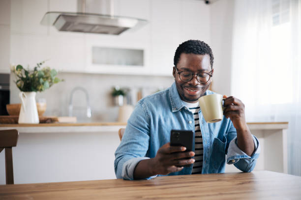 istock Shot of a young man with glasses using a smartphone and having coffee 1859908651