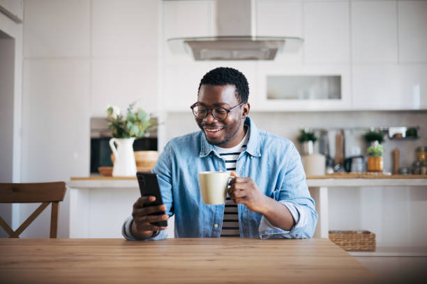 istock Shot of a young man with glasses using a smartphone and having coffee 1859910795