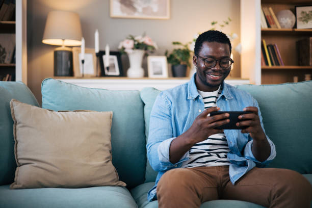 istock Young black man excited playing mobile game on his smartphone 1859918713