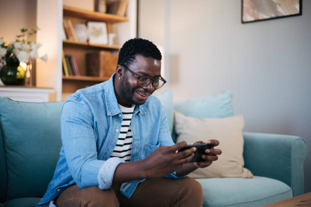 istock Young black man playing mobile game on his smartphone 1859919948