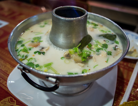 Served in a distinct bowl, the traditional Thai soup, Tom Kha Gai, presents its rich flavors and fragrant essence, embodying the essence of Thai culinary heritage.