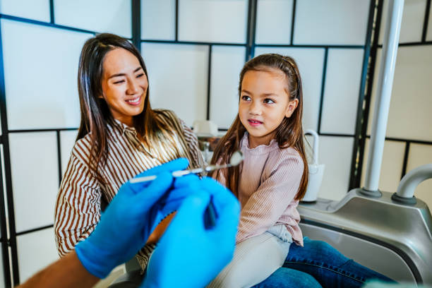 istock Girl examining her teeth at the dentist 1859991612