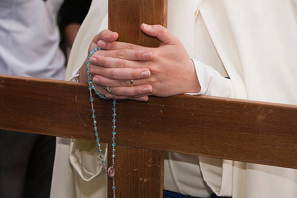 istock Penitent supports their hands crossed with a rosary 185999493