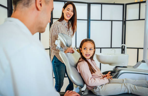 istock Cute girl at the dentist for a routine checkup 1859998919