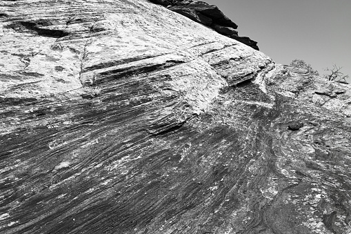 Retro black and white arid, desert landscape of weather eroded sandstone layers and a cloudless sky in Canyonland National Park Utah