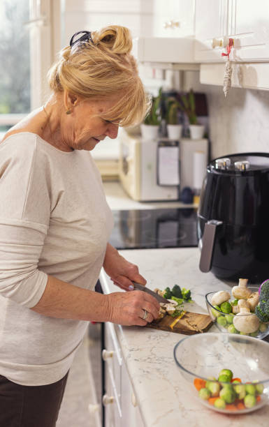 istock Senior woman chopping vegetables in the kitchen 1860034463