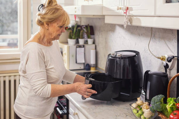 istock Senior woman using air fryer in the kitchen 1860035544