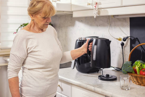 istock Senior woman using electric kettle to make tea 1860036128