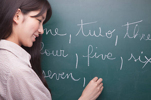 istock Young woman student writing English numbers on blackboard 186003627