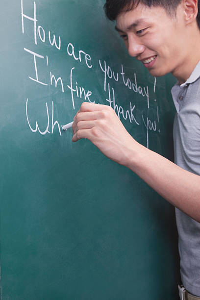 istock Young man writing English sentences on the blackboard 186003807