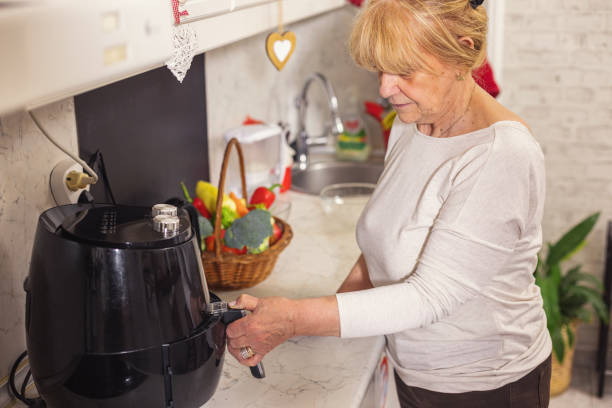 istock Senior woman using air fryer in the kitchen 1860046229