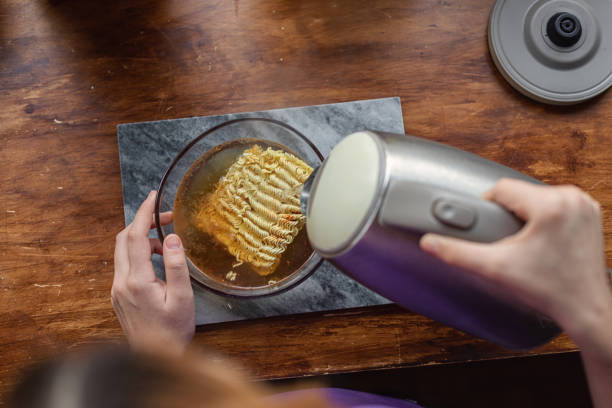 Beautiful teenage girl using an electric kettle to make noodle soup Beautiful teenage girl using an electric kettle to prepare noodle soup girls getting ready to go out stock pictures, royalty-free photos & images