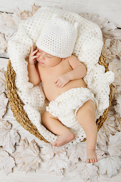 istock Newborn baby sleeping in white woolen basket 186006154