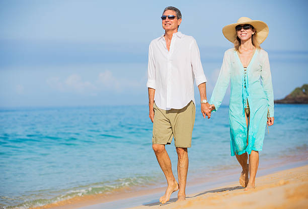 istock Middle Aged Couple Enjoying Walk on the Beach 186007450