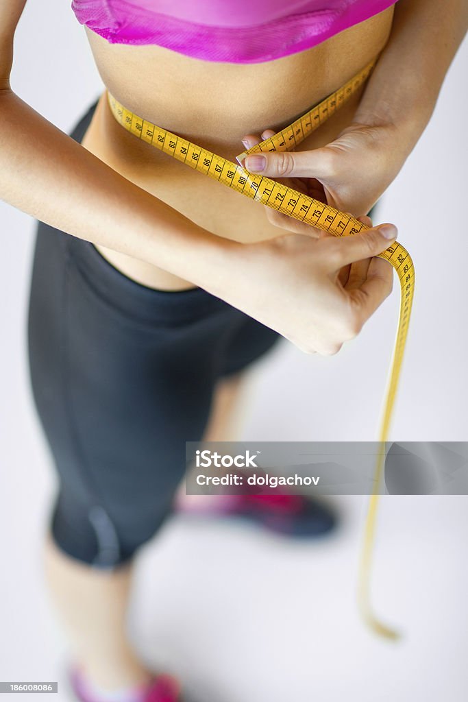 trained belly with measuring tape sport and diet concept - trained belly with measuring tape Abdomen Stock Photo