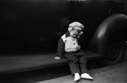 2 year old boy on running board of vintage car, taken in NYC 1949.