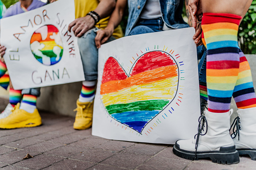 Close-up of LGBTQIA+ people holding poster during manifestation outdoors