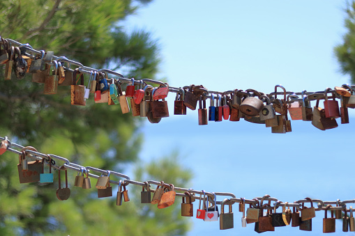 Makarska Croatia. Line of Love padlocks hanging on a chain by the sea. Love locks. Wedding locks. Symbol of eternal love. Valentine day. Colorful padlocks against the backdrop of the sea. Loyalty