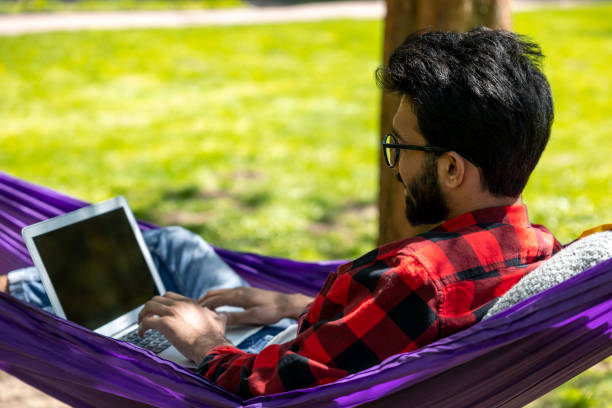 istock Digital nomad working on laptop in the park 1860189684