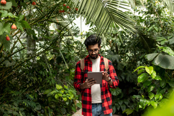istock Hindu man with tablet in hands in botanical garden 1860190296