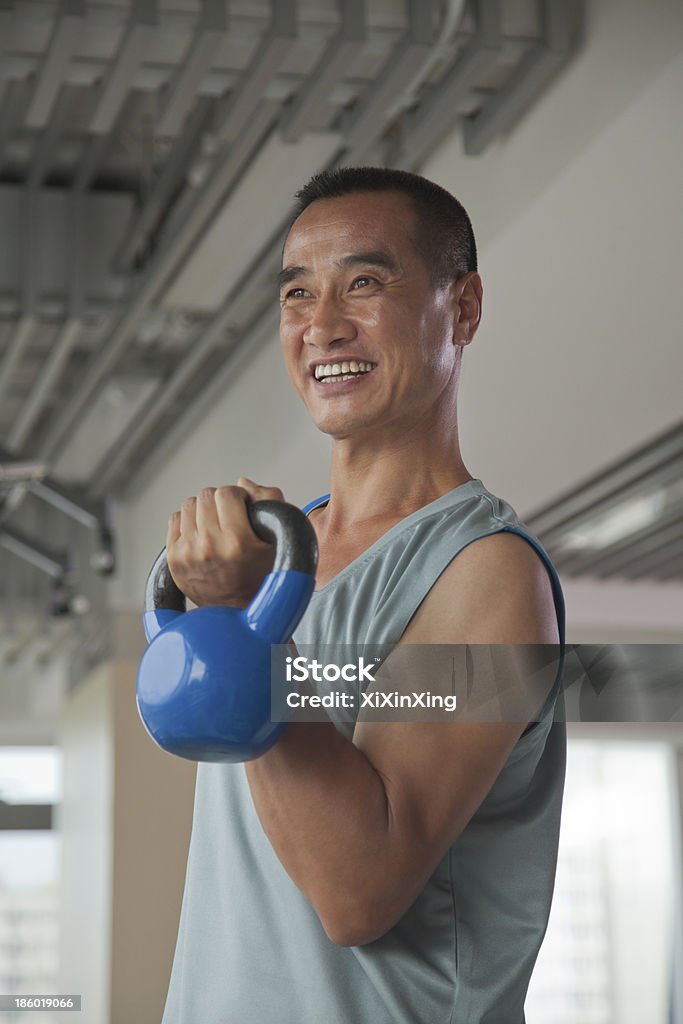 Homme d'âge mûr en train de soulever des poids et haltères dans la salle de sport - Photo de Adulte d'âge mûr libre de droits