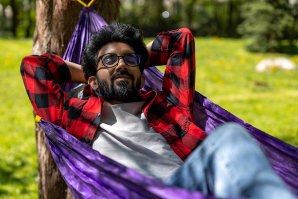 istock Hindu young man enjoying a day in a park while laying in hammock 1860190827
