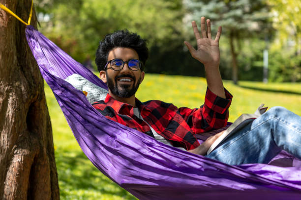 istock Hindu young man enjoying a day in a park while laying in hammock 1860190840