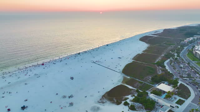 Parking lot for tourists cars in front of famous Siesta Key beach with soft white sand in Sarasota, USA at sunset. Popular vacation spot in warm Florida