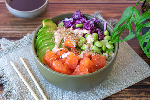 poke bowl with salmon on the wooden table