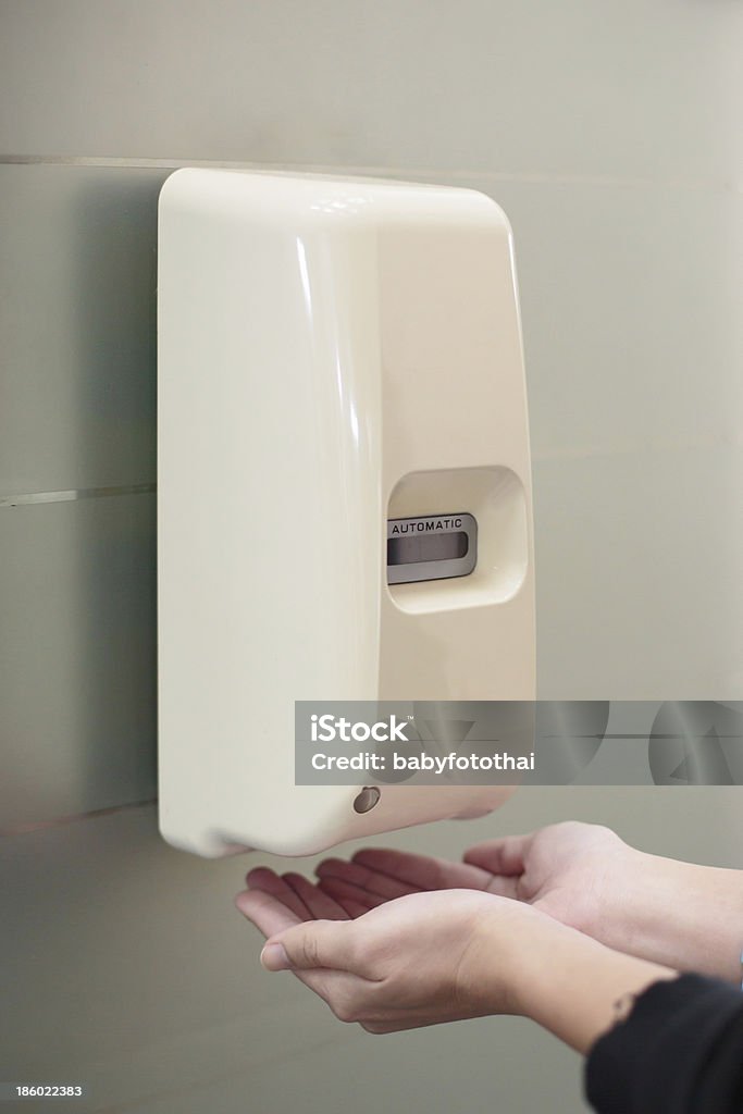 Distributore di sapone liquido automatico sulla parete - Foto stock royalty-free di Dosatore di sapone