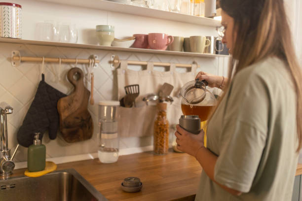 istock A woman pouring hot tea from a kettle into reusable cup 1860227108